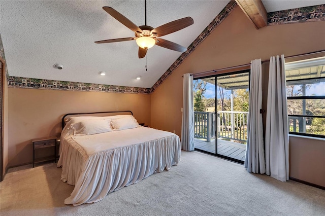 carpeted bedroom with access to exterior, a textured ceiling, ceiling fan, lofted ceiling with beams, and multiple windows