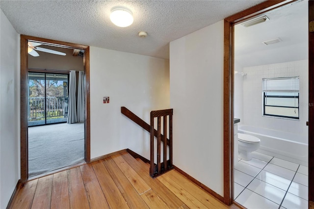 hallway featuring a textured ceiling and light wood-type flooring