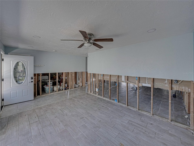 interior space with ceiling fan and a textured ceiling