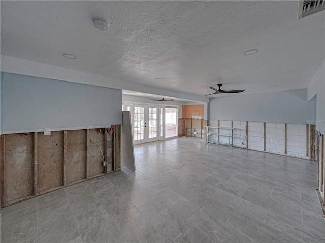 unfurnished living room with french doors and ceiling fan