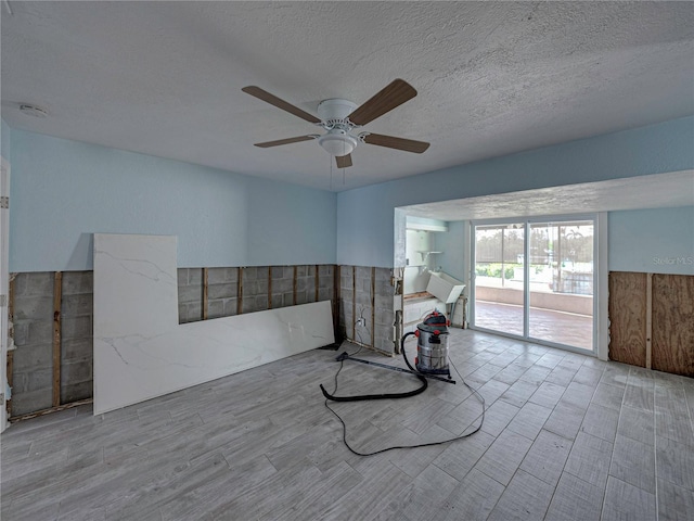 unfurnished room with ceiling fan, light hardwood / wood-style floors, and a textured ceiling