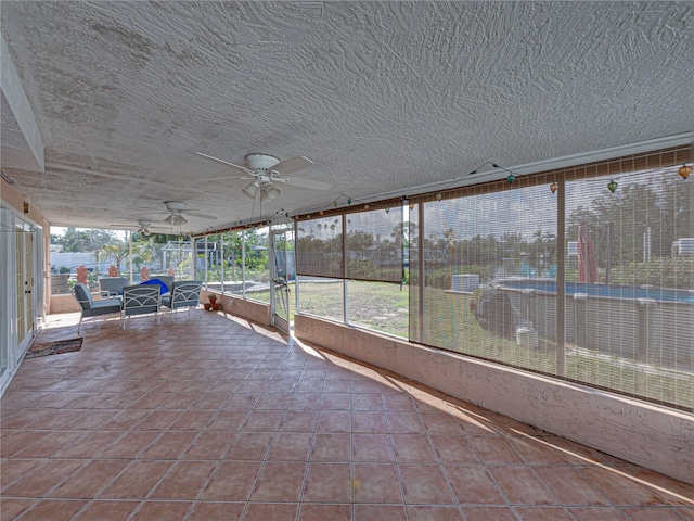 unfurnished sunroom featuring ceiling fan