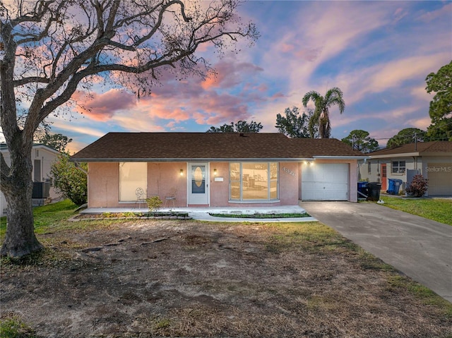 ranch-style house featuring central AC and a garage