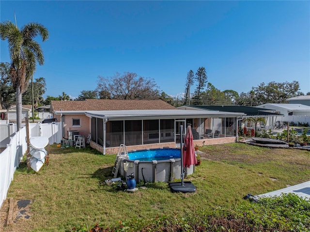 rear view of property featuring a sunroom and a yard