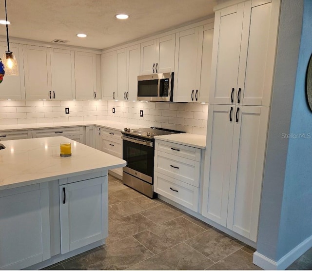 kitchen with tasteful backsplash, stainless steel appliances, white cabinetry, and hanging light fixtures