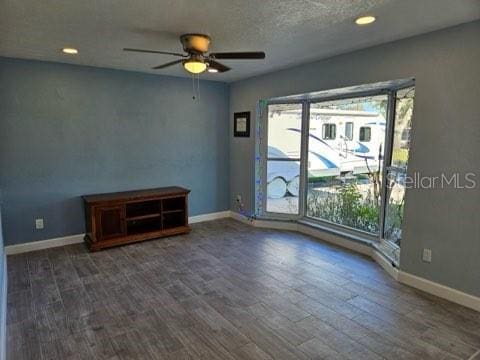 empty room featuring ceiling fan, dark hardwood / wood-style flooring, and a textured ceiling