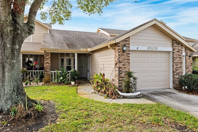 view of front of house featuring a porch, a front yard, and a garage