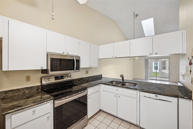 kitchen featuring a skylight, stainless steel appliances, sink, high vaulted ceiling, and white cabinets