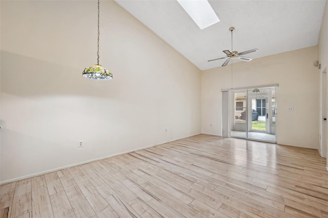 unfurnished living room featuring high vaulted ceiling, a skylight, light hardwood / wood-style flooring, and ceiling fan