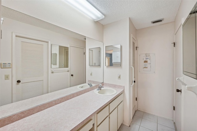 bathroom with tile patterned floors, vanity, and a textured ceiling