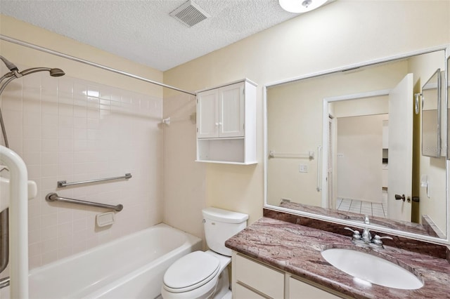 full bathroom featuring vanity, toilet, a textured ceiling, and tiled shower / bath