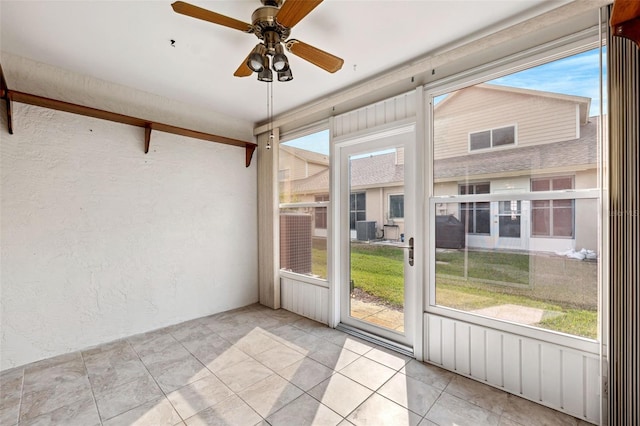 unfurnished sunroom featuring ceiling fan