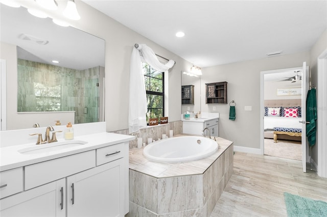 bathroom featuring a shower with door, ceiling fan, and vanity