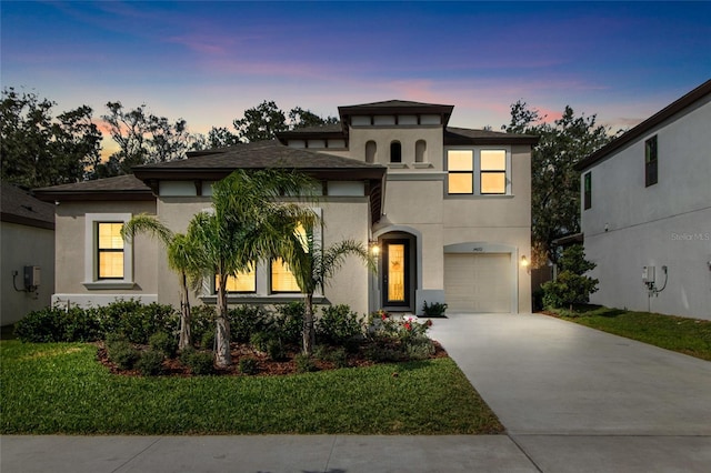 view of front of house with a garage and a yard