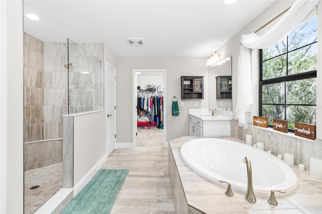 14672 Horse Trot Rd, Lithia, FL 33547 - full bath with vanity, a bath, a walk in shower, a spacious closet, and recessed lighting