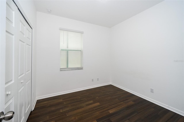 unfurnished bedroom featuring dark hardwood / wood-style floors and a closet