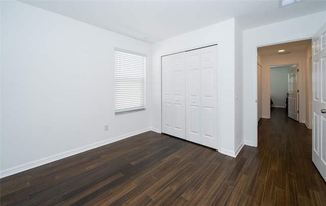 unfurnished bedroom featuring dark hardwood / wood-style flooring and a closet