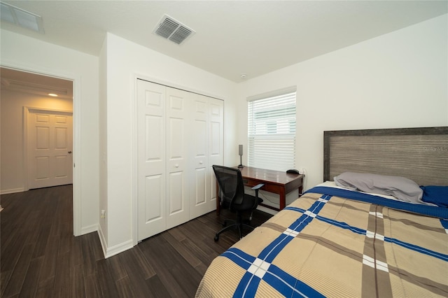 bedroom with dark wood-type flooring and a closet