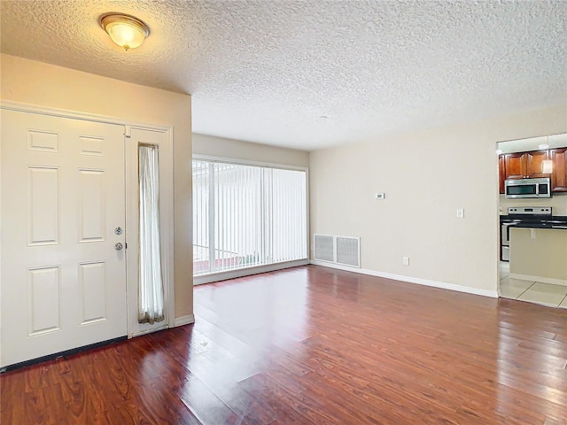 entrance foyer with a textured ceiling and dark hardwood / wood-style floors