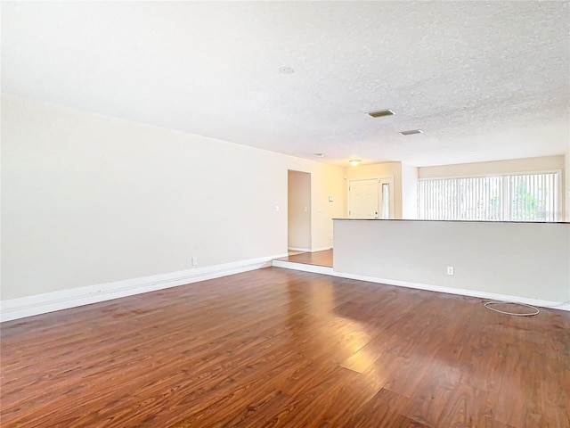 unfurnished room with a textured ceiling and hardwood / wood-style flooring