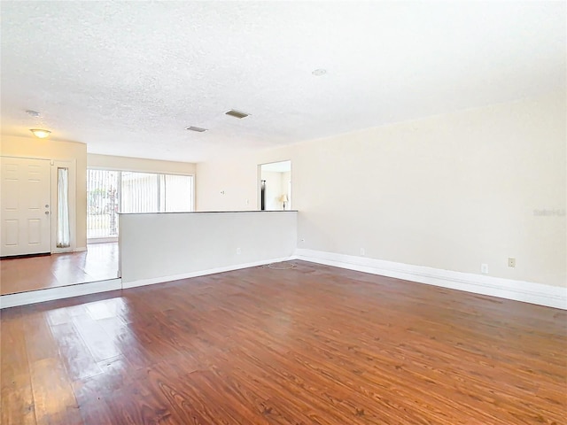 empty room featuring dark wood-type flooring and a textured ceiling