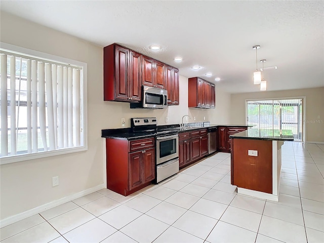 kitchen featuring a kitchen breakfast bar, stainless steel appliances, light tile patterned floors, decorative light fixtures, and a kitchen island