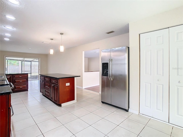 kitchen with stainless steel fridge with ice dispenser, light tile patterned floors, a kitchen island, and pendant lighting