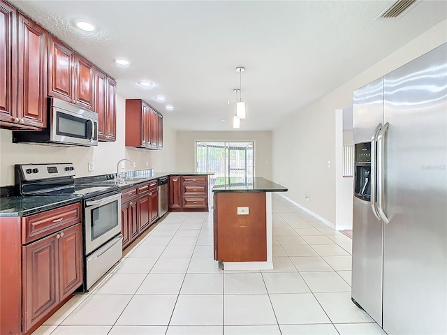 kitchen with a center island, hanging light fixtures, sink, light tile patterned floors, and appliances with stainless steel finishes