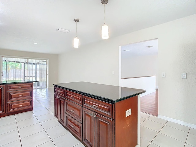 kitchen featuring a center island, light tile patterned floors, and decorative light fixtures