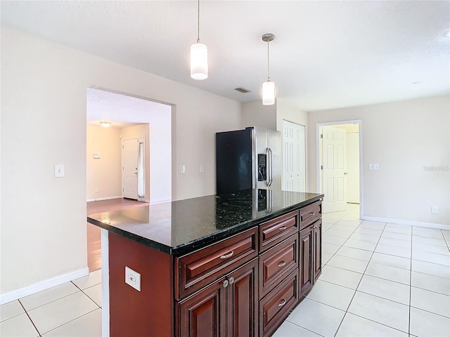 kitchen with light tile patterned floors, hanging light fixtures, stainless steel refrigerator with ice dispenser, and a kitchen island