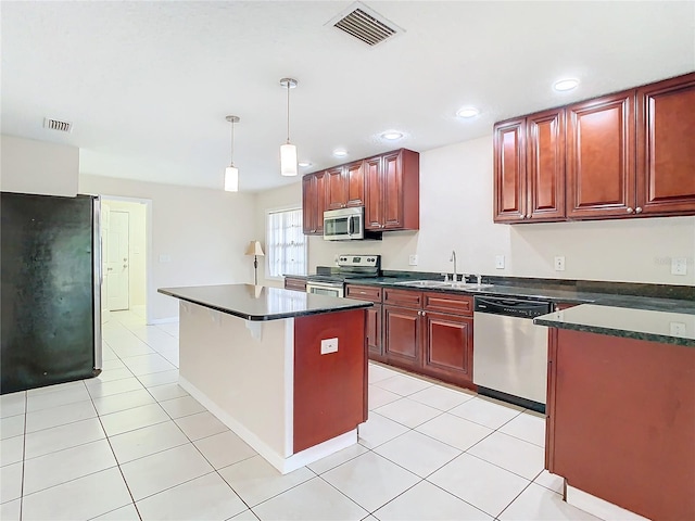 kitchen featuring sink, hanging light fixtures, stainless steel appliances, light tile patterned floors, and a kitchen island