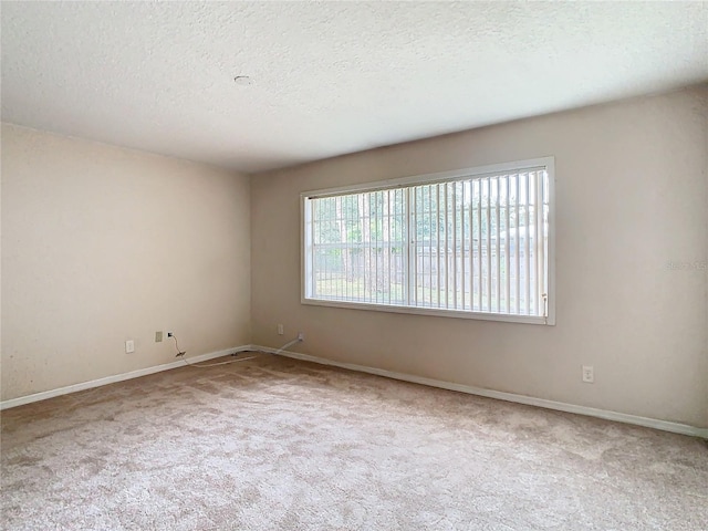 carpeted spare room featuring a textured ceiling