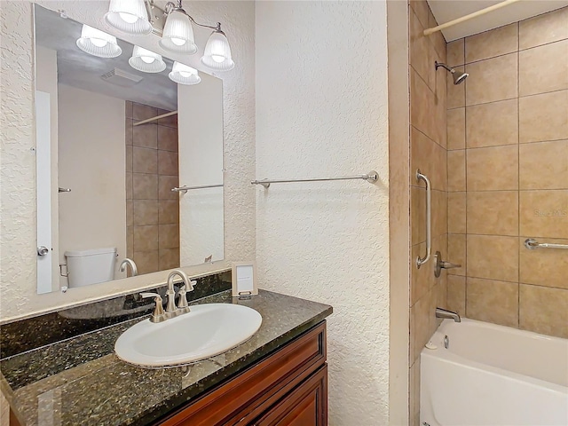 full bathroom with vanity, tiled shower / bath combo, and toilet