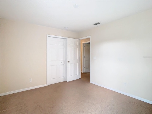 unfurnished bedroom featuring carpet flooring and a closet