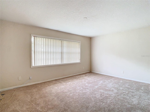 carpeted spare room featuring a textured ceiling