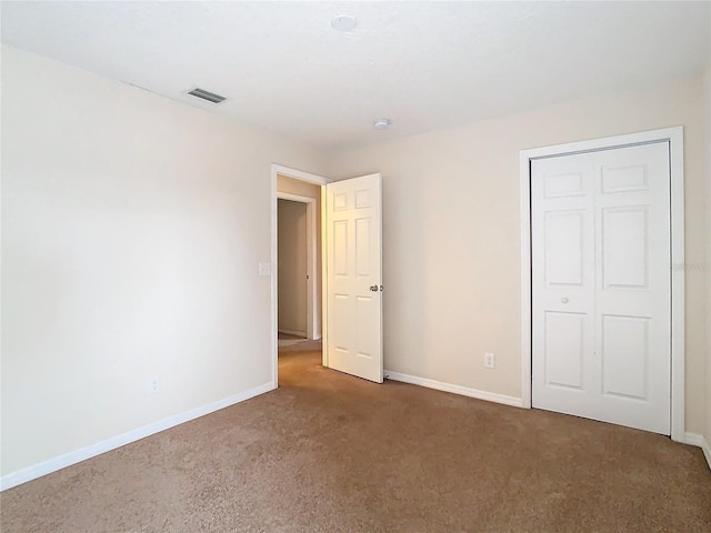 unfurnished bedroom with carpet and a closet