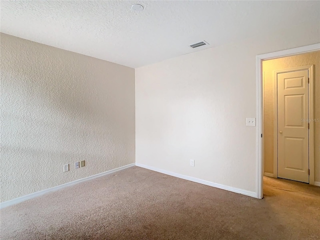 unfurnished room with carpet flooring and a textured ceiling