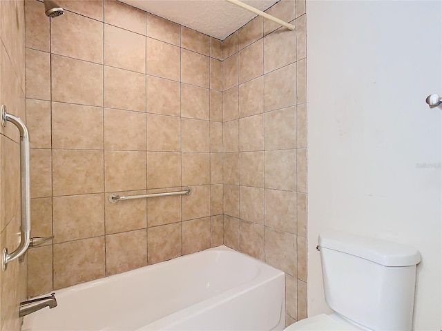 bathroom featuring tiled shower / bath combo and toilet