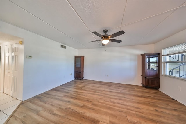 unfurnished room featuring a textured ceiling, light hardwood / wood-style flooring, and ceiling fan