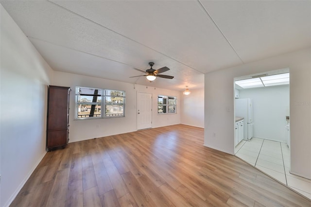 spare room featuring ceiling fan, light hardwood / wood-style floors, and a textured ceiling