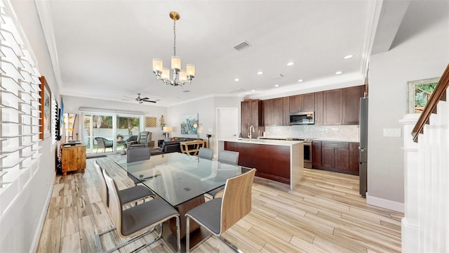 dining area with ceiling fan with notable chandelier, light wood-type flooring, ornamental molding, and sink