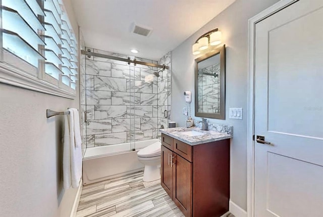 full bathroom with hardwood / wood-style floors, toilet, vanity, and enclosed tub / shower combo