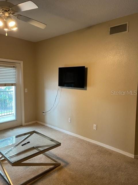 unfurnished room featuring ceiling fan and carpet