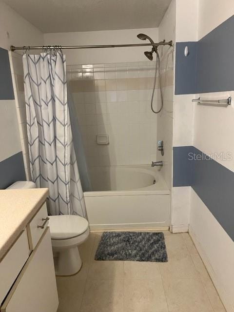 full bathroom with tile patterned flooring, shower / bath combination with curtain, vanity, and toilet