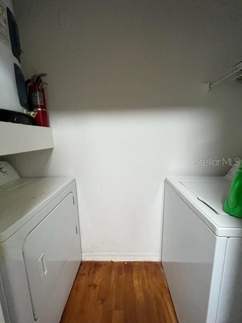 washroom featuring hardwood / wood-style floors and washer and clothes dryer