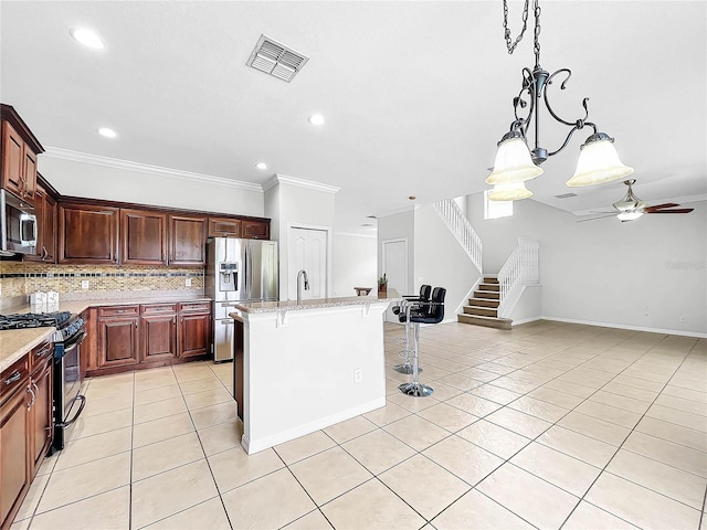 kitchen with light stone countertops, ceiling fan, stainless steel appliances, a breakfast bar area, and ornamental molding