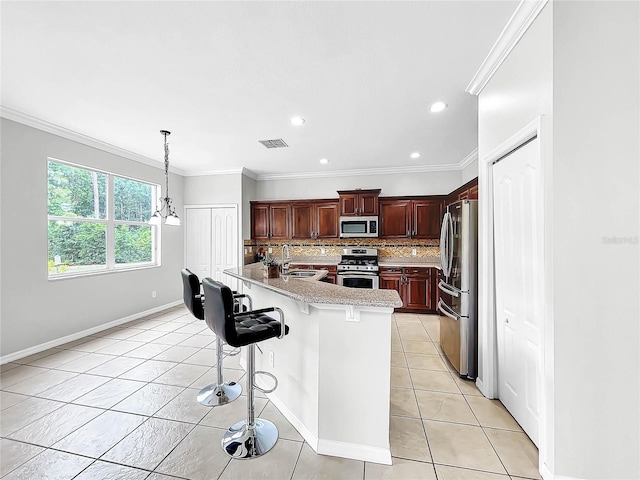 kitchen with sink, stainless steel appliances, a notable chandelier, backsplash, and a kitchen island with sink