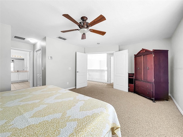 bedroom with ensuite bathroom, ceiling fan, and light colored carpet