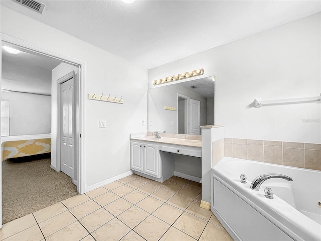 bathroom with a tub, tile patterned flooring, and vanity