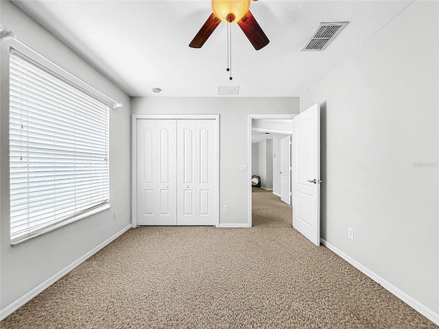 unfurnished bedroom with ceiling fan, a closet, and carpet